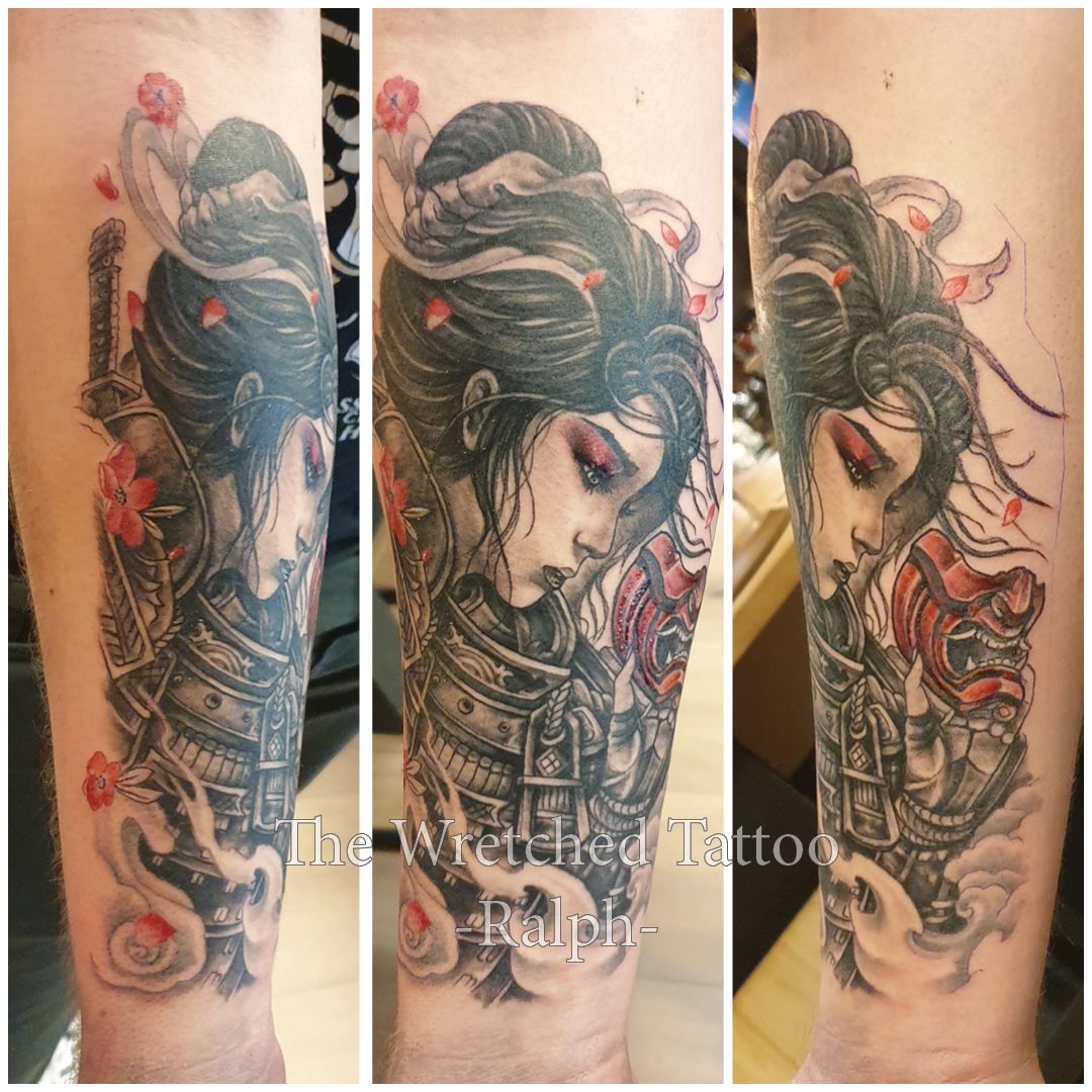 Vrouwelijke samoerai met masker en kersenbloesems op onderarm.