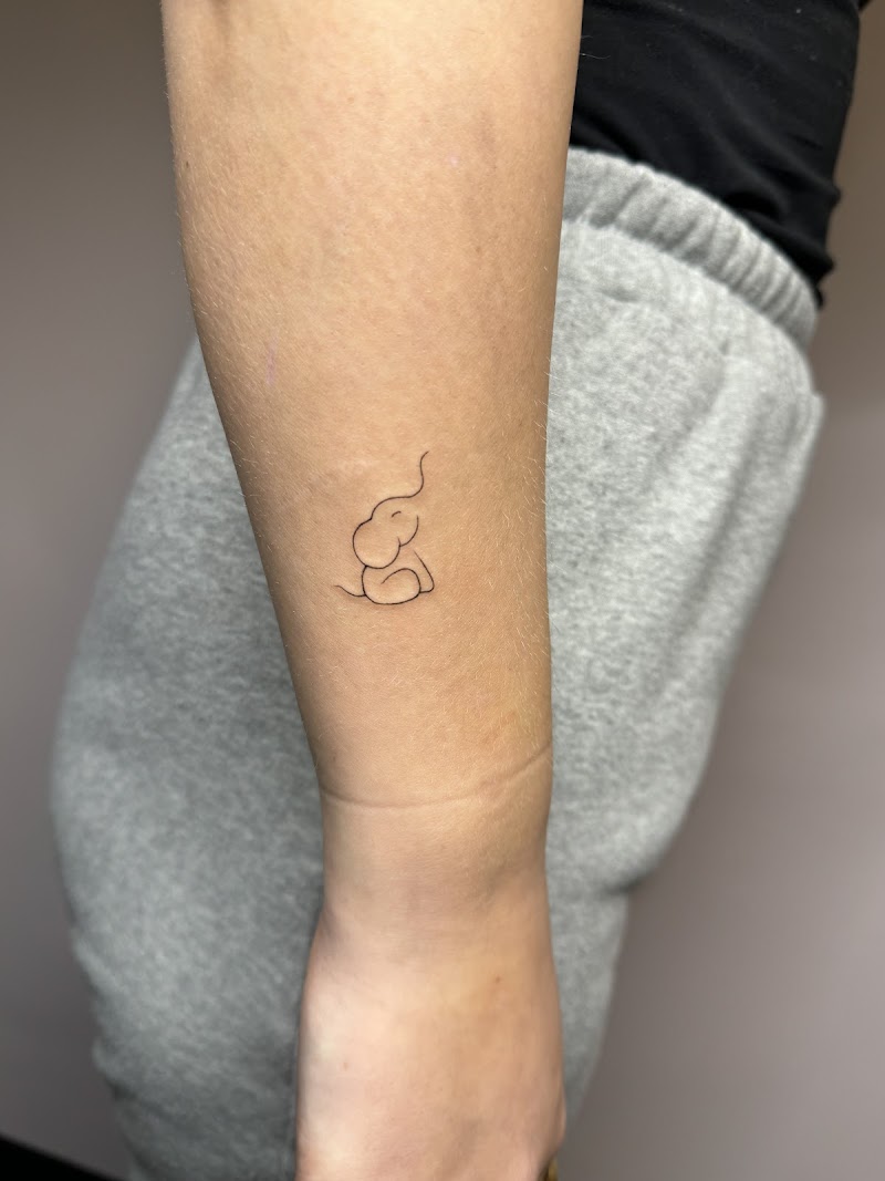 Minimalistische fineline olifant tattoo op de pols.