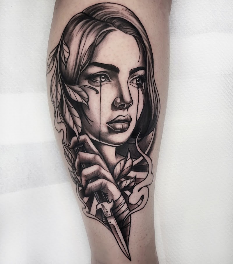 Zwart-wit tattoo van een huilende vrouw die een dolk vasthoudt, met bladeren.