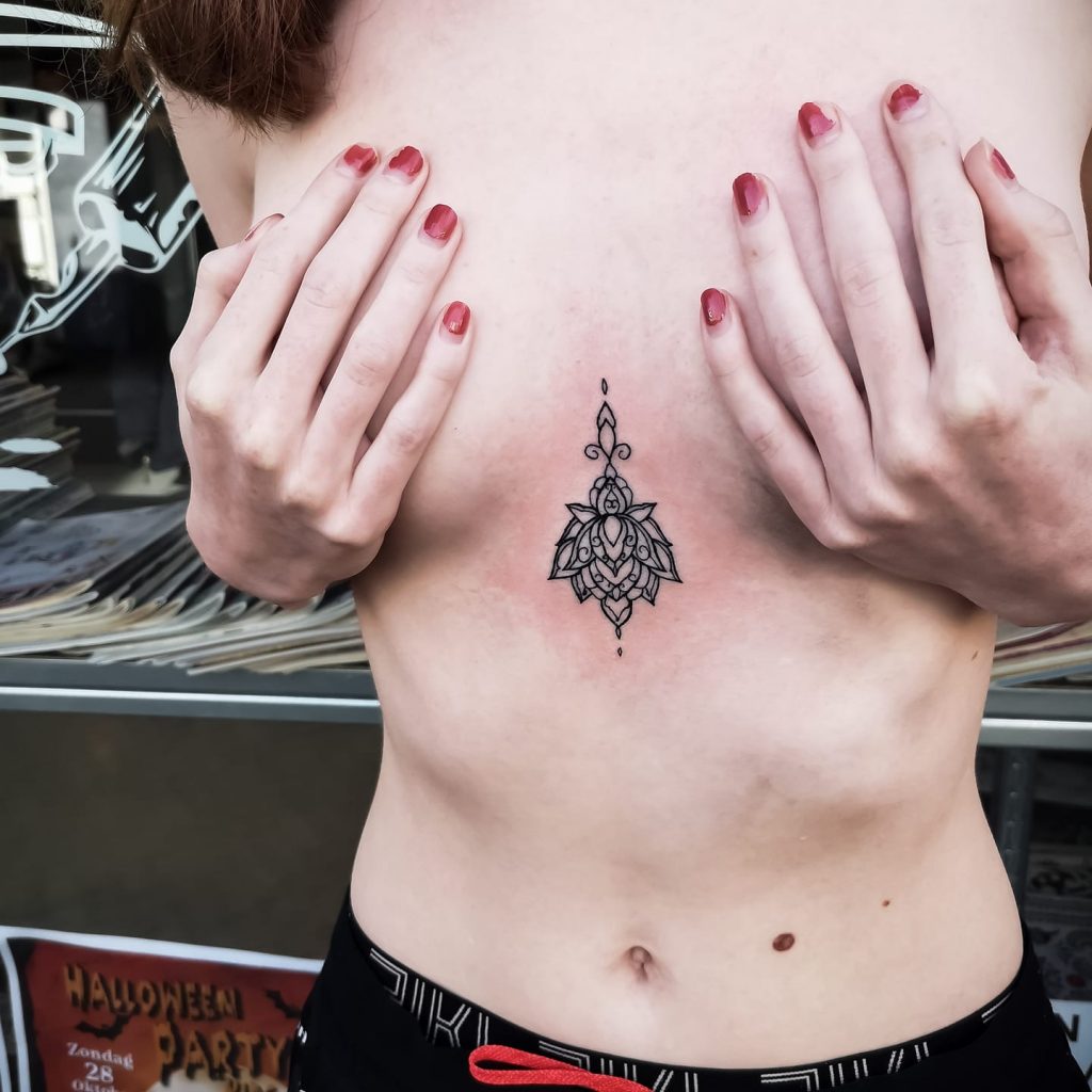 Elegante fineline mandala tattoo op het borstbeen.