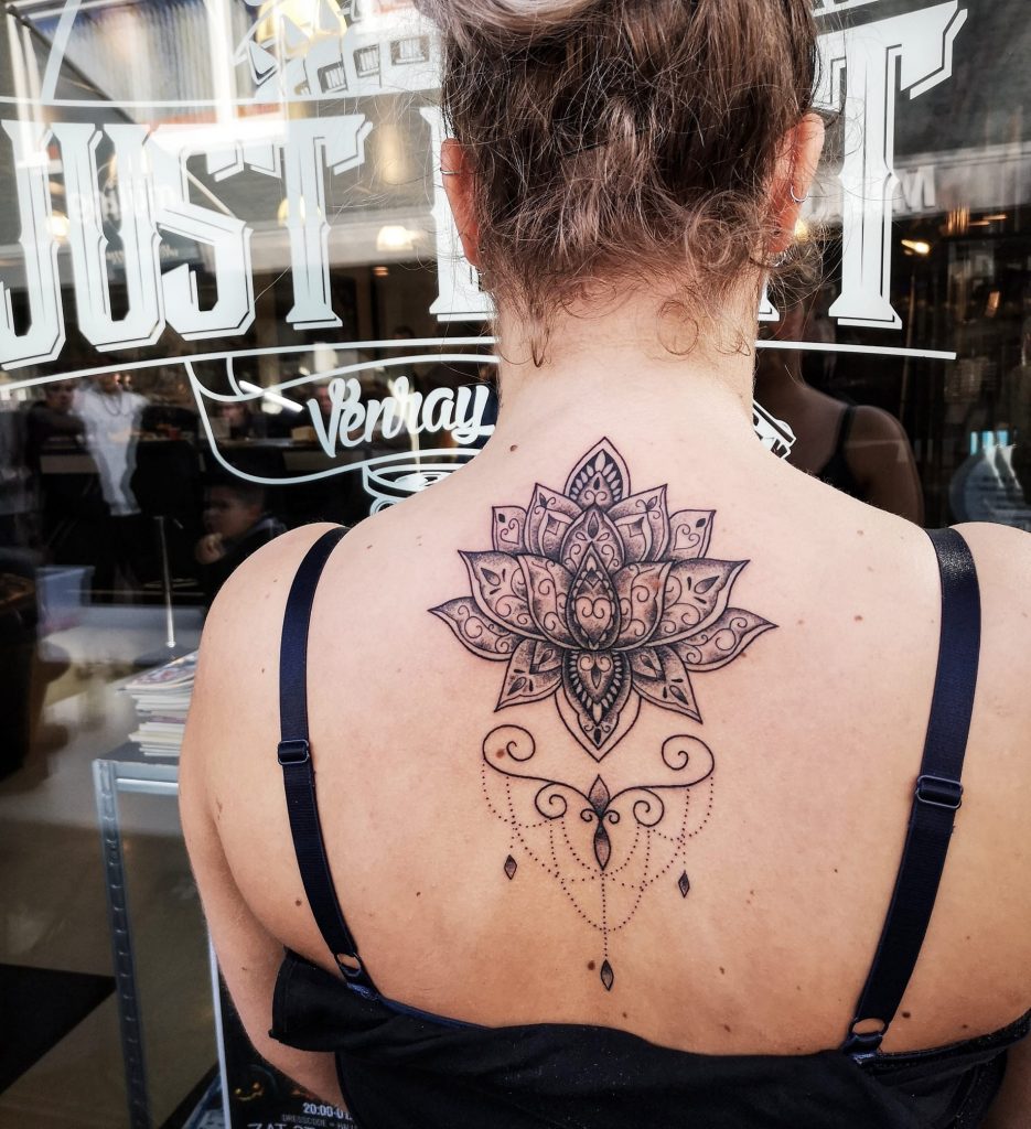 Grote lotusbloem met sierlijke ornamenten en dotwork op de bovenrug.