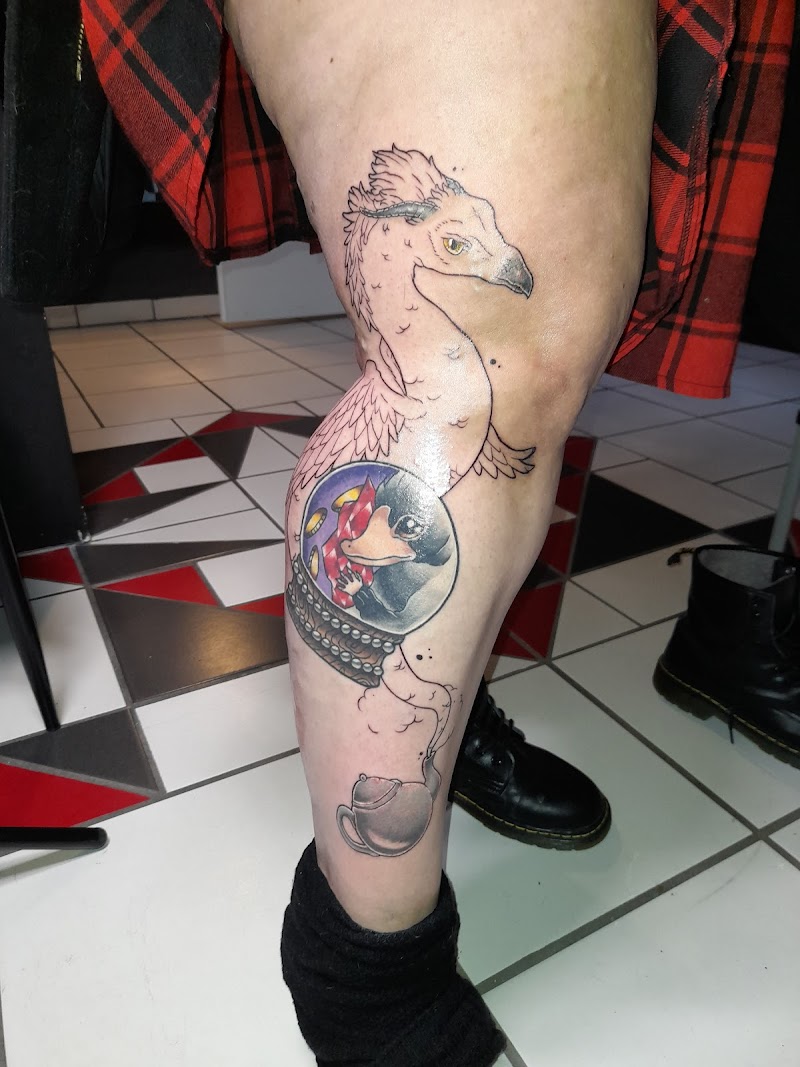Illustratieve tattoo van een Niffler in een glazen bol met een Occamy erboven.