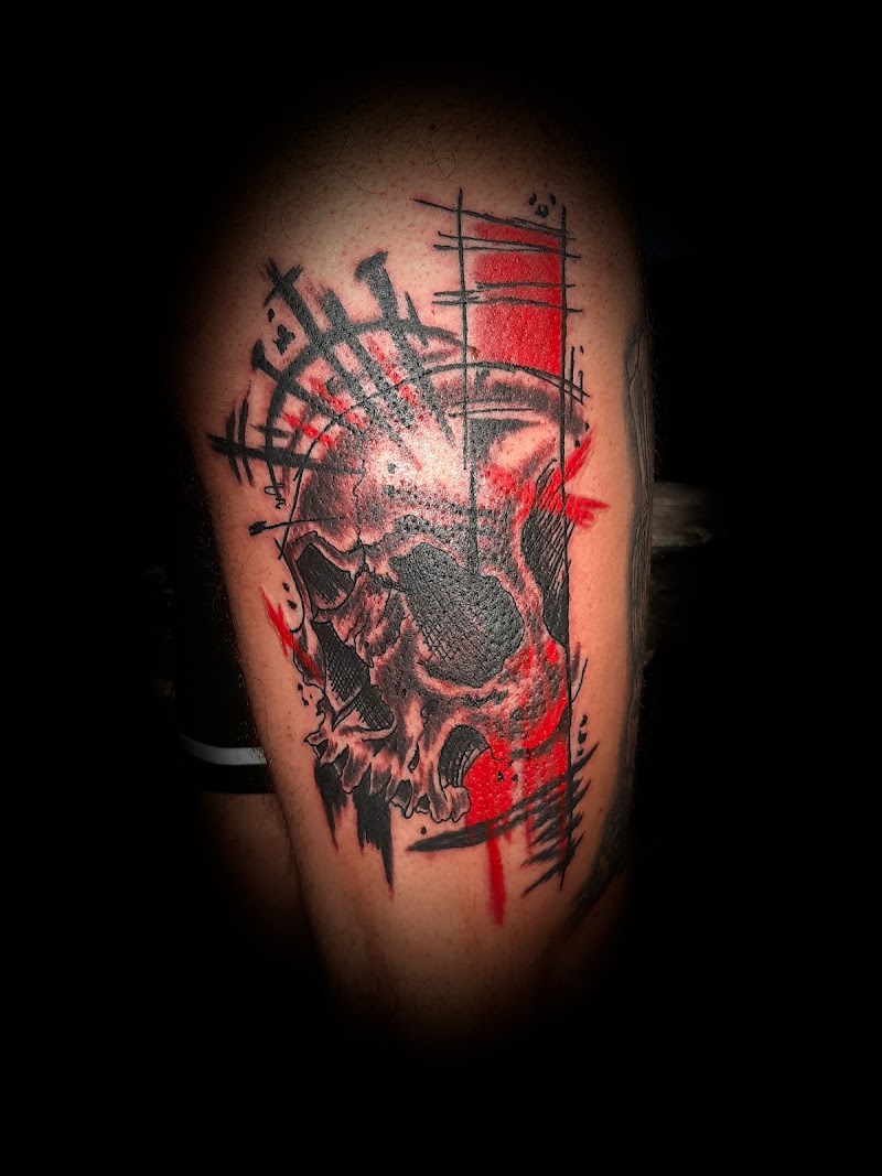 Schedel tattoo met rode en zwarte abstracte elementen.