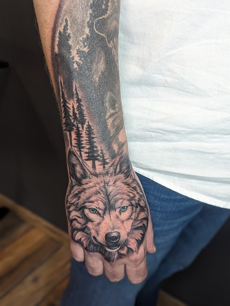 Realistische wolf met blauwe ogen op hand, bos op onderarm.