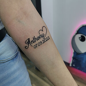 "Anthony" naam met hartje en datum 07.09.2022 op onderarm.