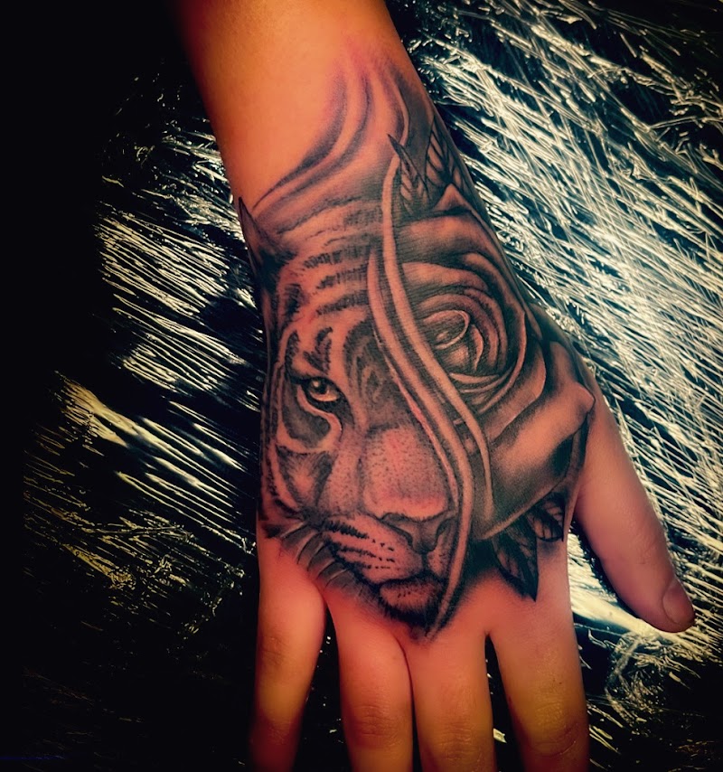 Realistische tijger en roos morph tattoo op hand.