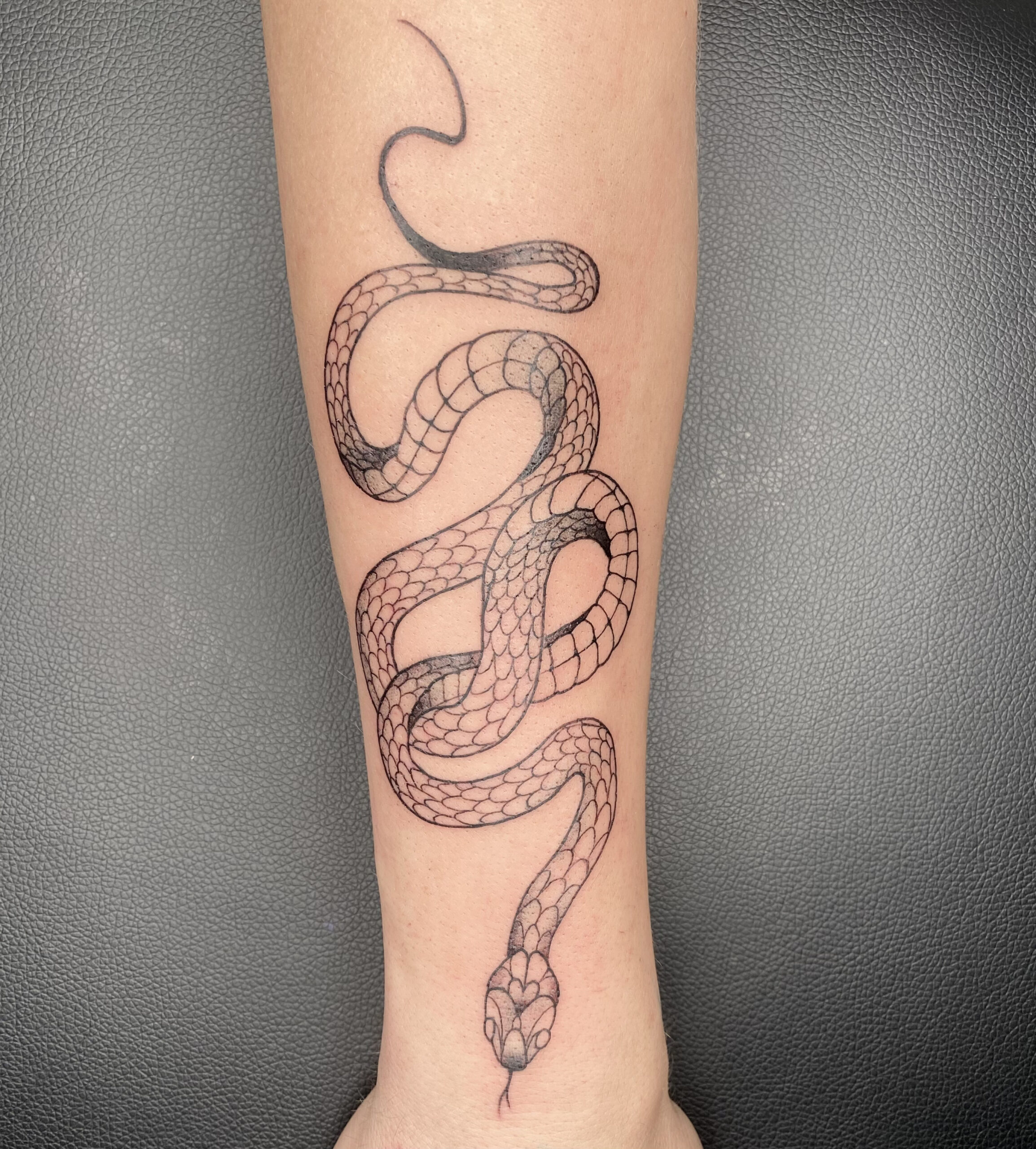 Fineline slang tattoo op onderarm.