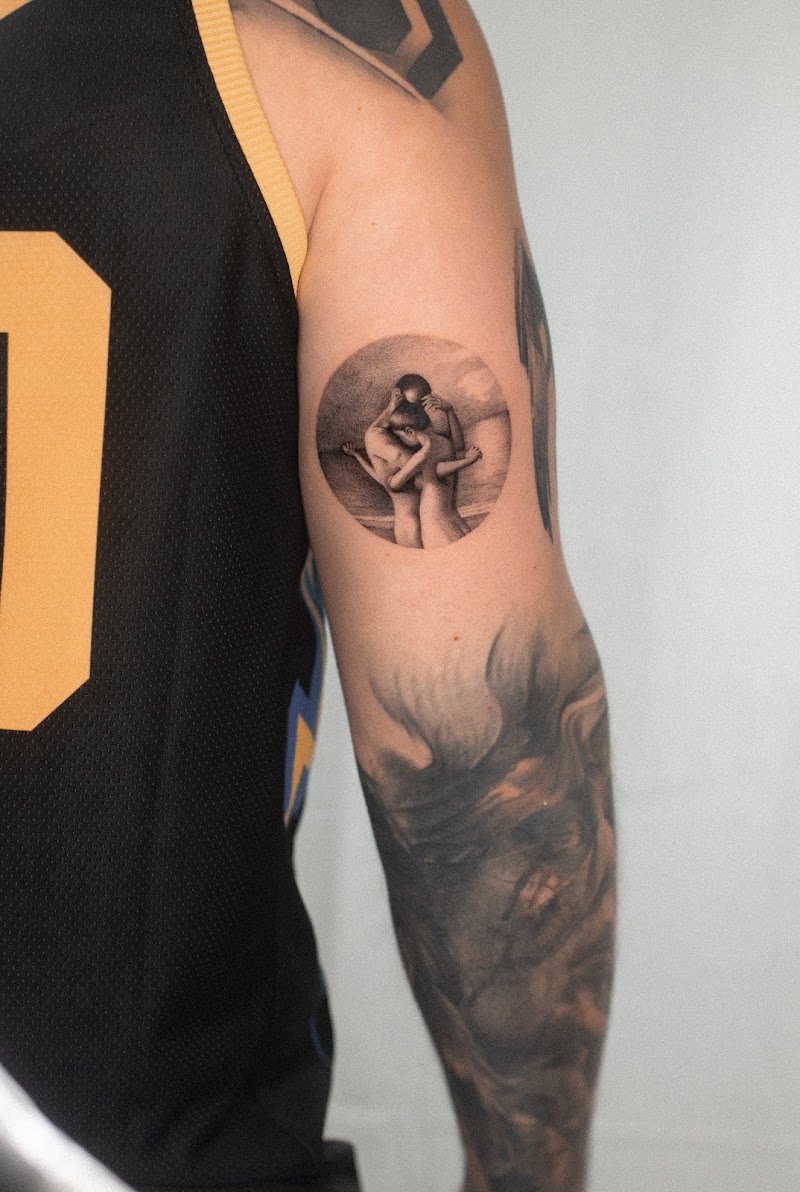 Realistische cirkeltattoo van een omhelzend koppel op het strand.