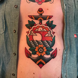 Traditional anker met zonsondergang en bloem op de buik.