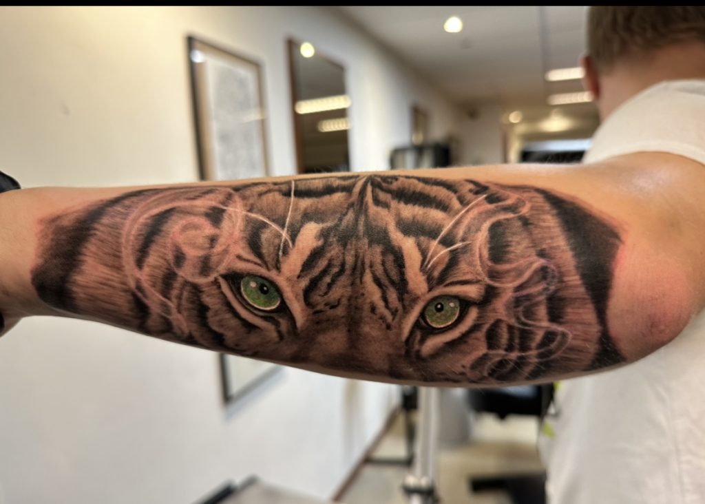 Realistische tijgerogen met groene ogen op bovenarm