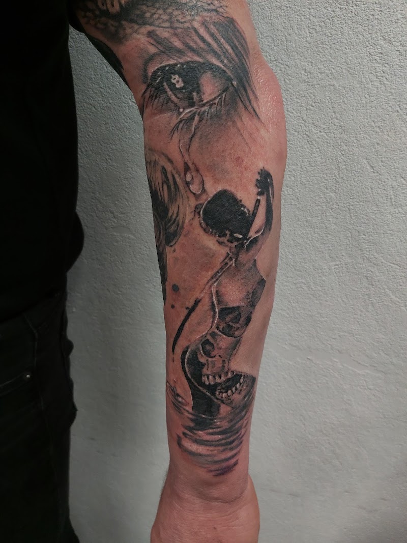 Realistisch oog en figuur met schedel in water op onderarm.