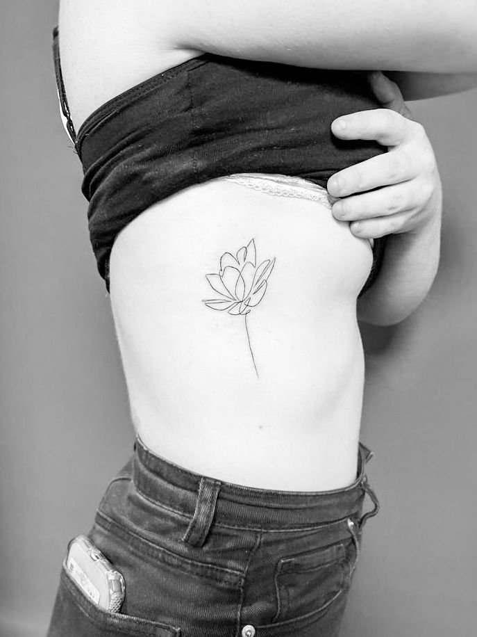 Minimalistische fineline lotusbloem op de ribben.