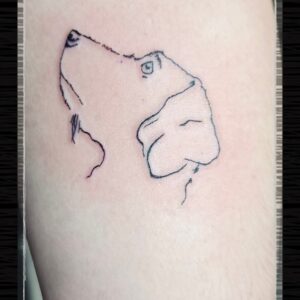 Minimalistische fineline tattoo van een hondenkop.