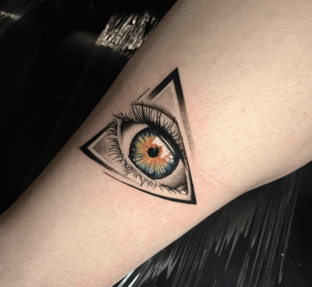 Realistisch oog met kleur in een driehoek op het onderbeen.