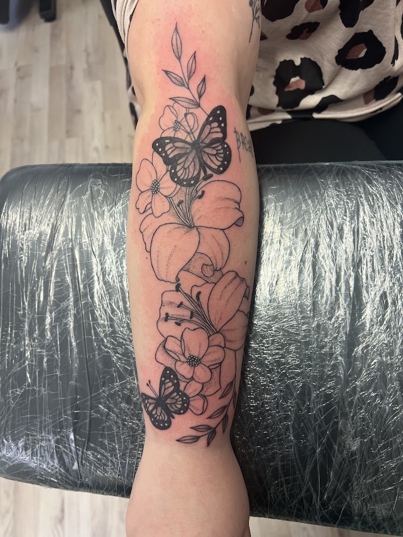 Fineline bloemen en vlinders op onderarm.