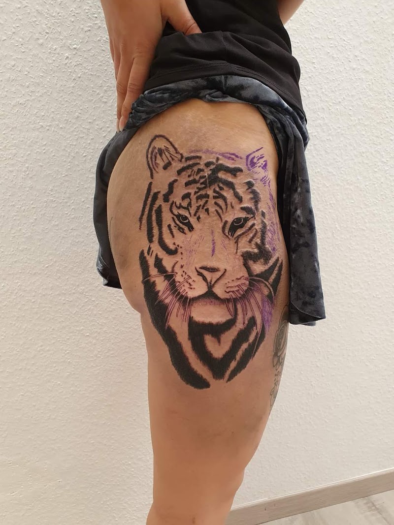 Realistische zwart-wit tijgerkop tattoo op bovenbeen.