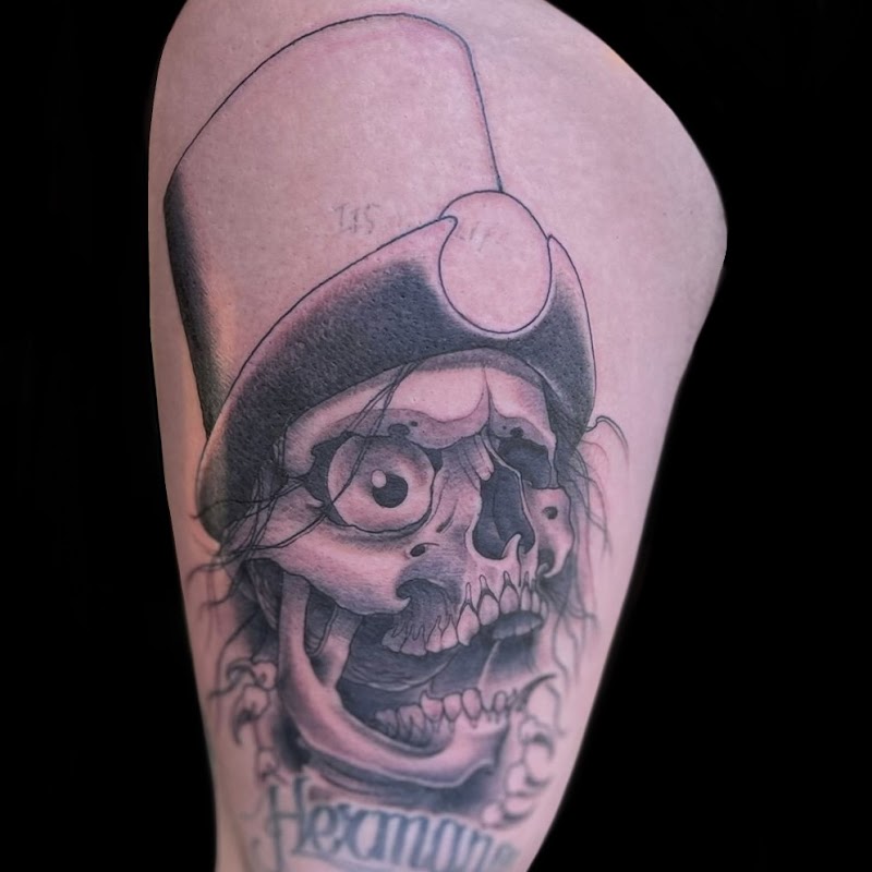 Zwart-wit tattoo van een schedel met een hoge hoed en een groot oog.