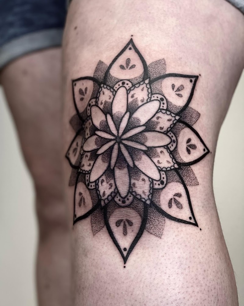 Gedetailleerde mandala tattoo op de knie met dotwork en blackwork.