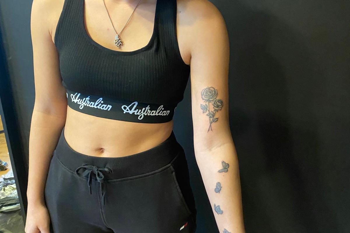 Fineline rozen en vlinders op de linkerarm.