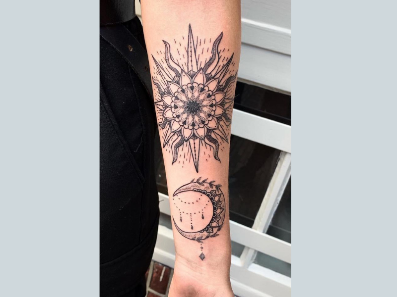Dotwork zon en maan met mandala patronen op onderarm.