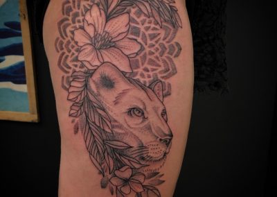 Leeuwin met bloemen en mandala achtergrond in dotwork stijl.