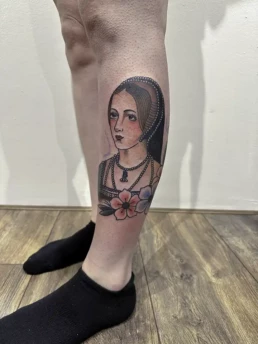 Traditionele tattoo van een historische vrouwenbuste met bloemen op het onderbeen.