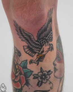 Traditionele adelaar tattoo in duikvlucht op onderbeen.