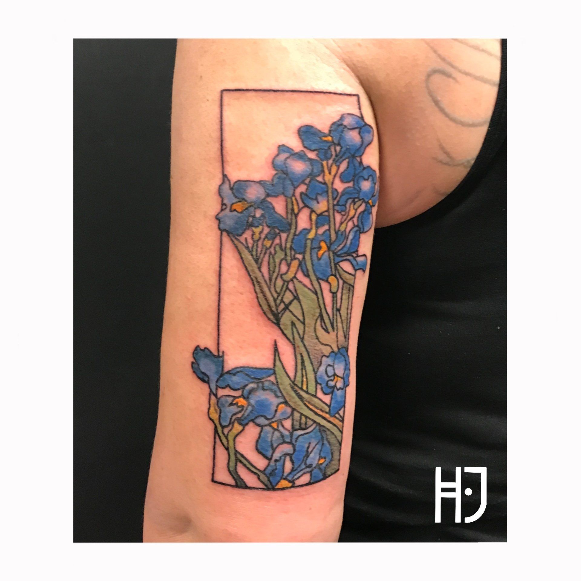 Kleurrijke irissen in een rechthoekig kader op de bovenarm.