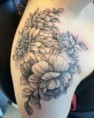 Zwart-wit bloemenboeket tattoo op de schouder.
