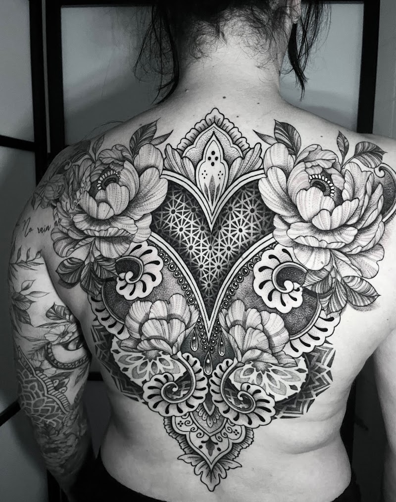 Grote rugtattoo met mandala, bloemen en geometrische patronen in dotwork.