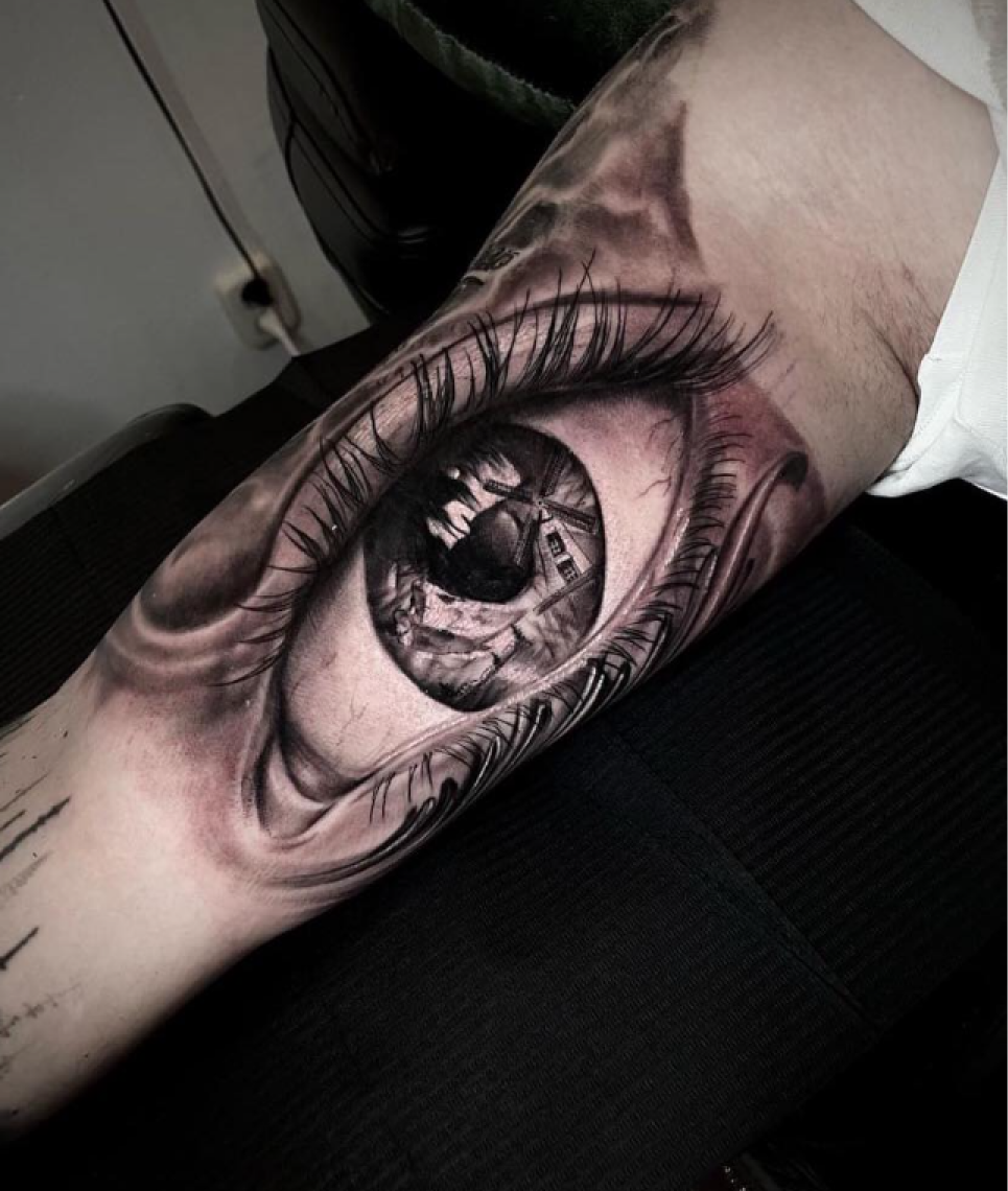Realistisch oog met een molen in de pupil op de bovenarm.
