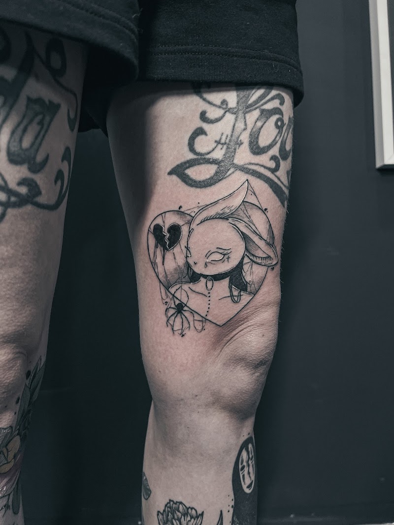 Blackwork tattoo van een konijn in een hart met een gebroken hart en spin.