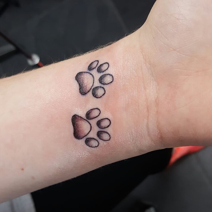 Twee kleine hondenpootjes op de pols.