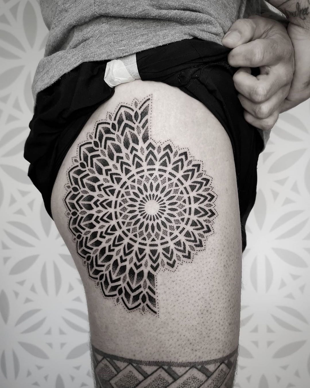 Grote dotwork mandala tattoo op het bovenbeen.