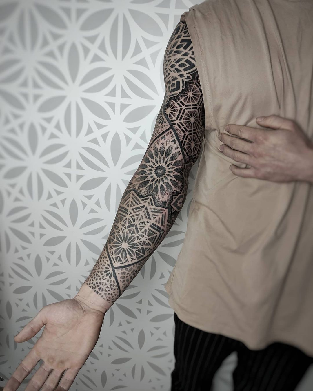 Geometrische sleeve tattoo met mandala patronen en dotwork.