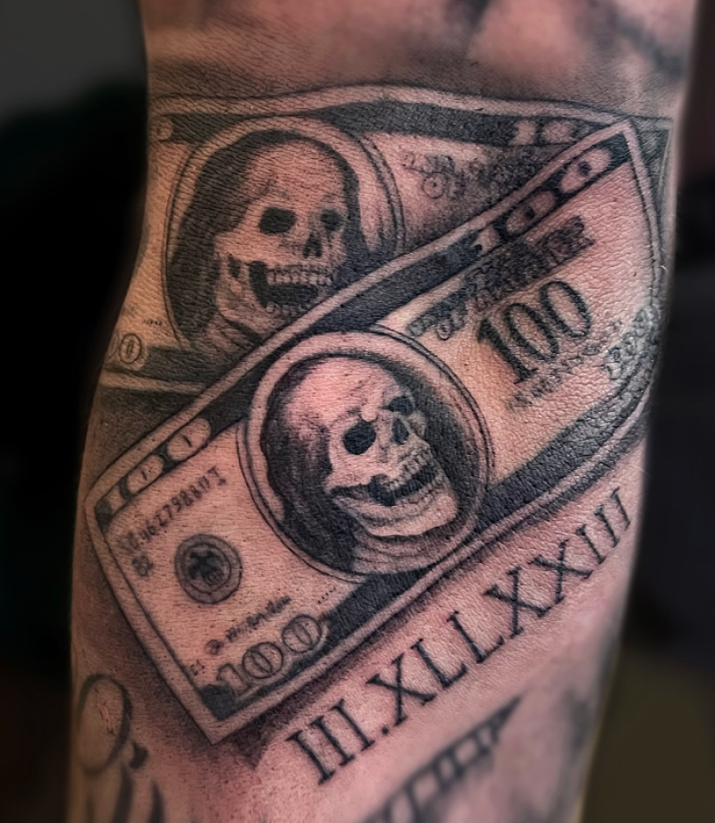 Blackwork tattoo van twee 100 dollar biljetten met schedels en Romeinse cijfers.