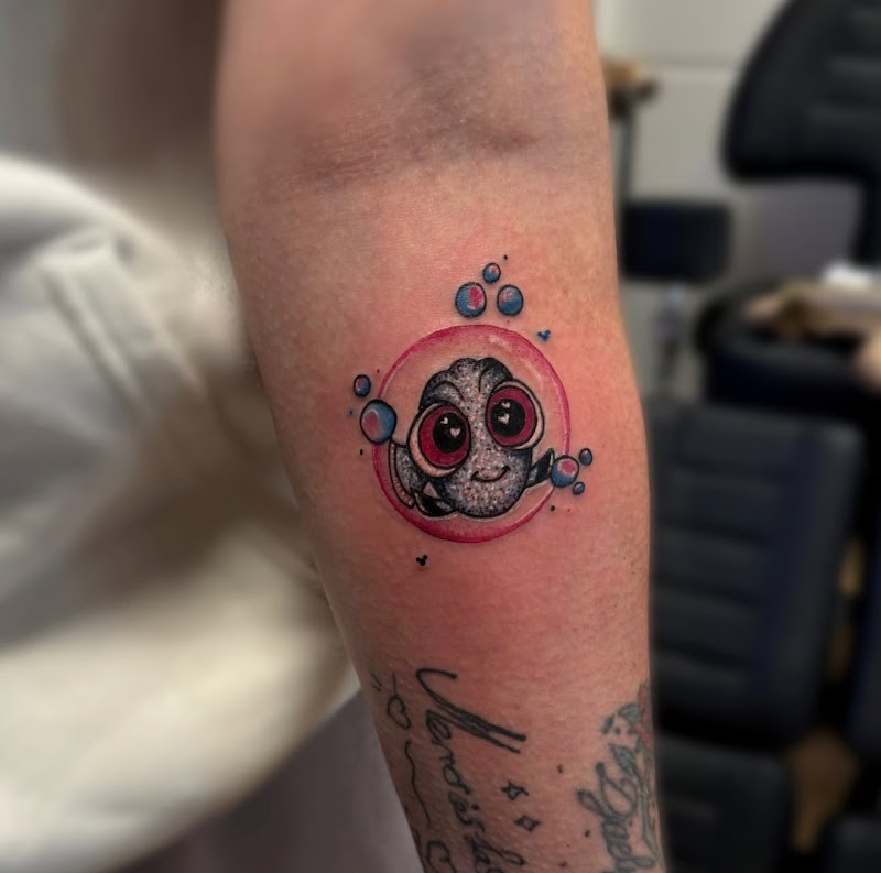 Schattige baby Dory vis in een roze bubbel op de onderarm.