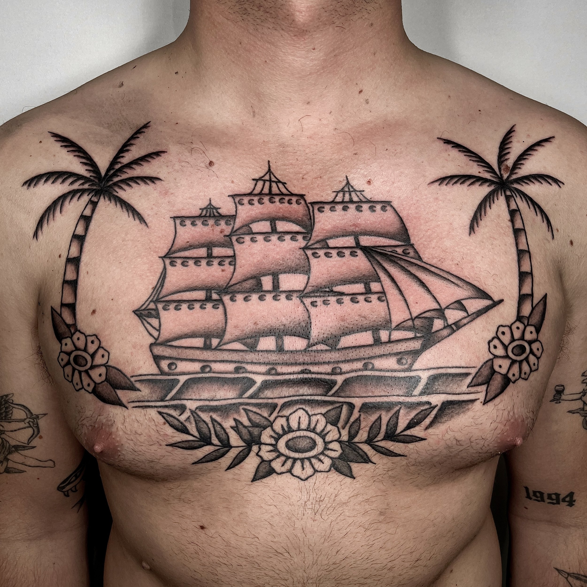 Traditional schip met palmbomen en bloemen op borst.