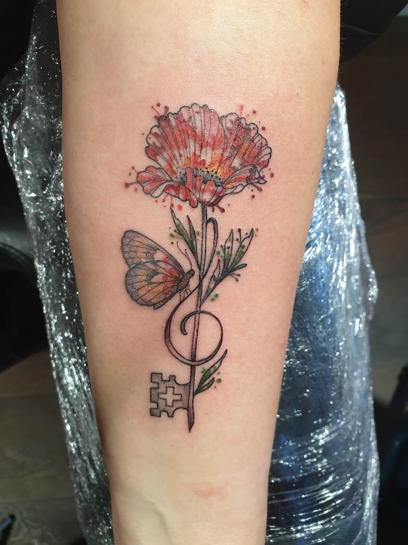 Watercolor klaproos met vlinder en muzieksleutel-sleutel op onderarm.