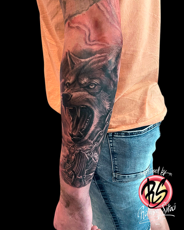 Realistische grommende wolf met ketting en figuur op onderarm.