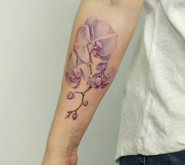 Realistische paarse orchideeën op de onderarm.