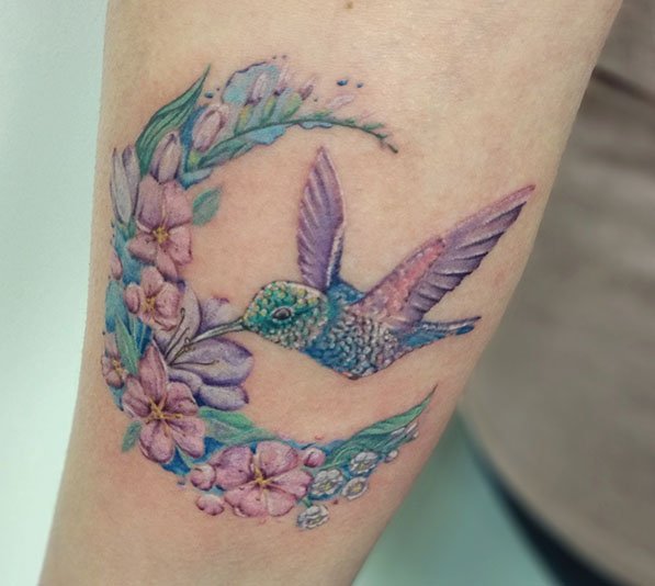 Kleurrijke kolibrie met bloemen halve maan op arm