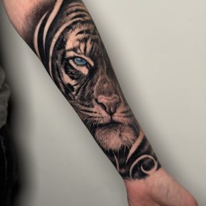 Realistische tijger met blauw oog op onderarm.