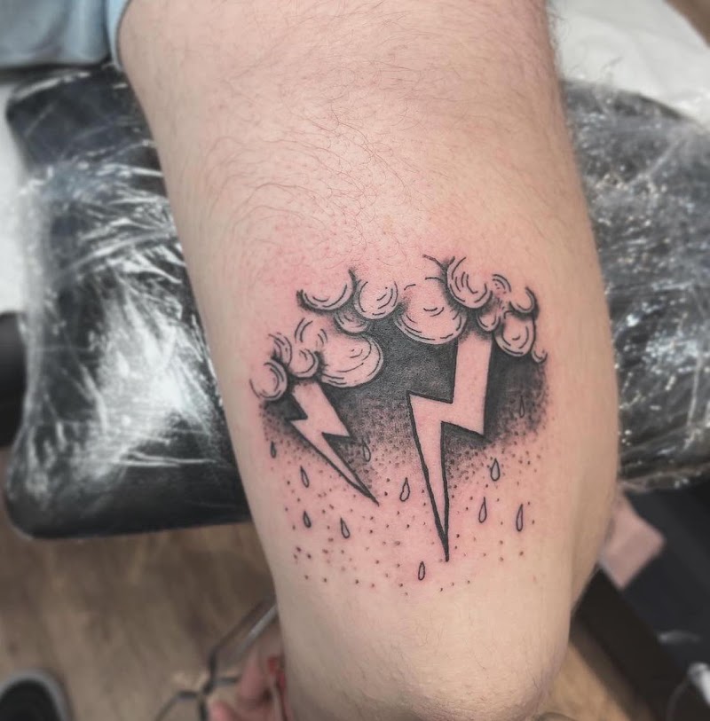 Zwart-wit tattoo van een onweerswolk met bliksem en regen.