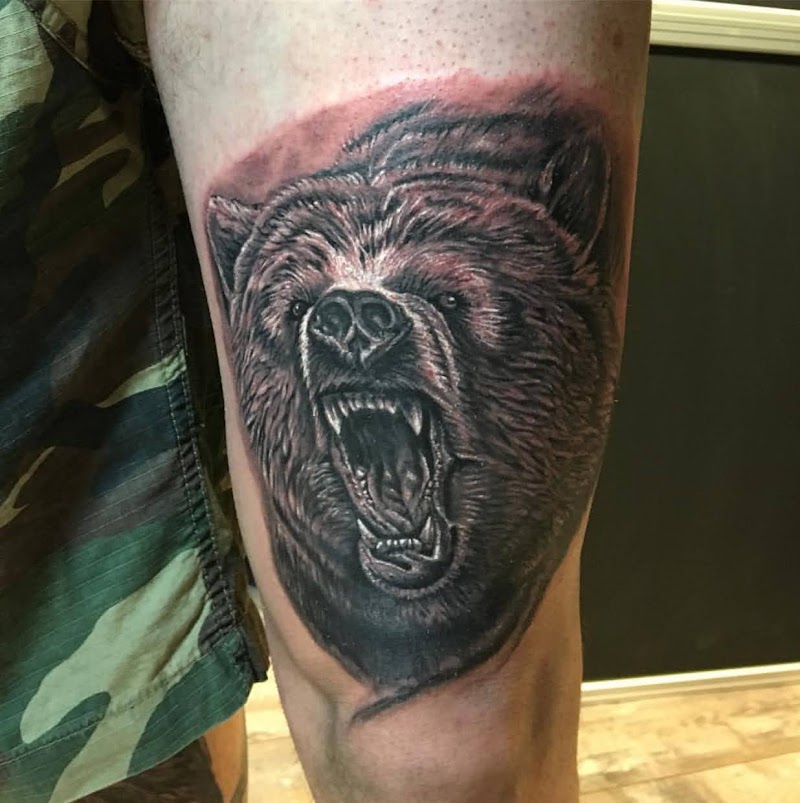 Realistische brullende beer op bovenbeen.