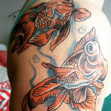 Twee oranje goudvissen in neo-traditional stijl op de schouder.